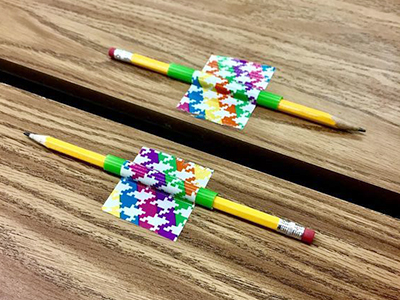 pencils taped to a desk