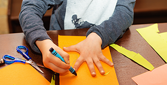 Boy using Fiskars scissors